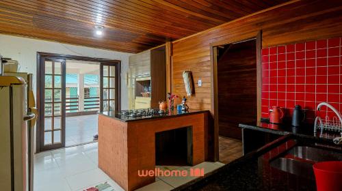a kitchen with a fireplace and red tile at Casa em Mangaratiba com 3 suites e Vista Mar in Mangaratiba