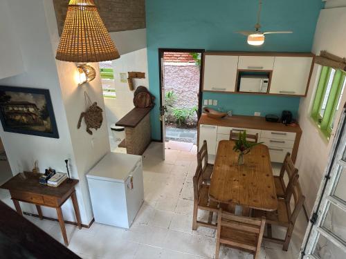 eine Küche und ein Esszimmer mit Tisch und Stühlen in der Unterkunft Vila dos Tangarás, Casa 1 Praia, a 30m do mar in Toque Toque Grande