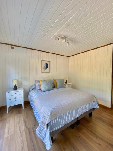 a bed in a room with a white ceiling at Cabañas Los Robles in Coelemu