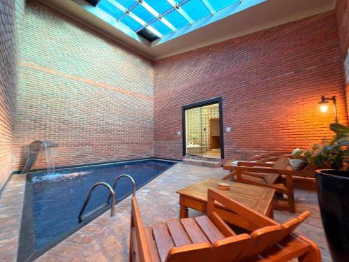 a swimming pool in a room with a table and chairs at Status Motel Ourinhos in Ourinhos