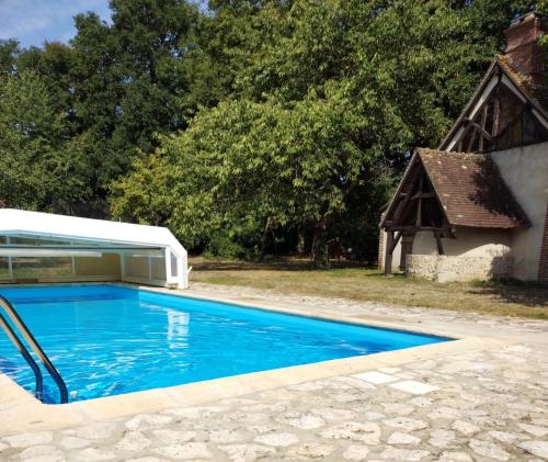 ein Pool neben einem Haus und einem Gebäude in der Unterkunft Maisonnette au calme 