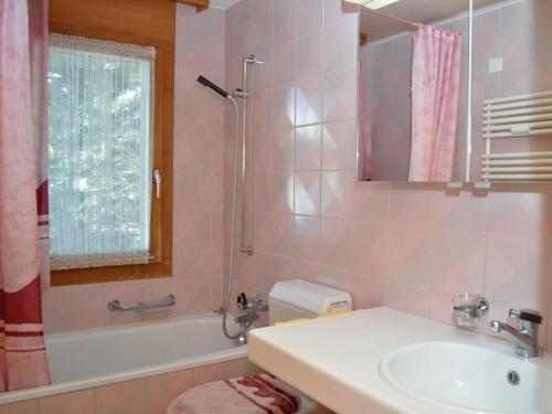 a pink bathroom with a sink and a shower at Rottal 4 Bett Wohnung in Mürren