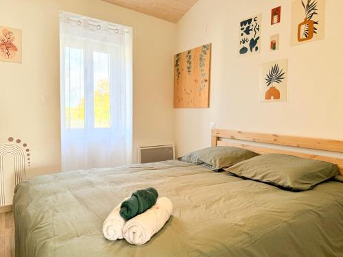 Un dormitorio con una cama con dos toallas encima. en Le Cocon Kaya T3 Wifi HD, à 10 min de La Rochelle, en Puilboreau