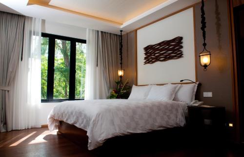 a bedroom with a bed and a large window at Tanjung Rhu Resort in Tanjung Rhu 