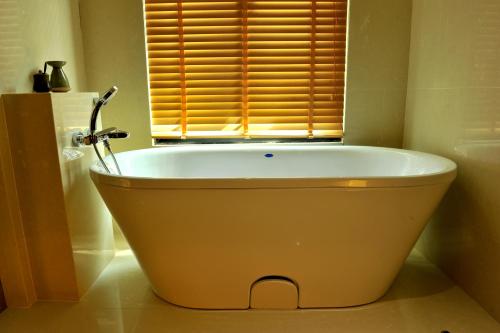 a bath tub in a bathroom with a window at Tanjung Rhu Resort in Tanjung Rhu 