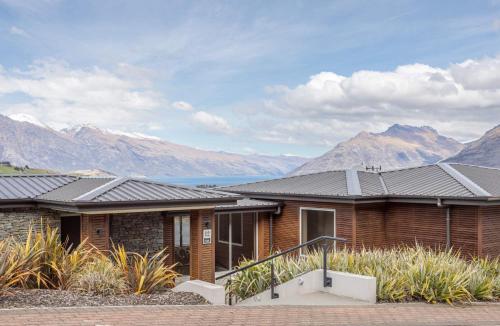 a house with mountains in the background at Bel Lago - every room with a lake view in Queenstown