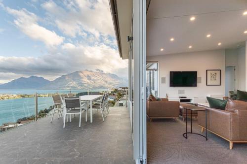 a living room with a view of the ocean and mountains at Bel Lago - every room with a lake view in Queenstown