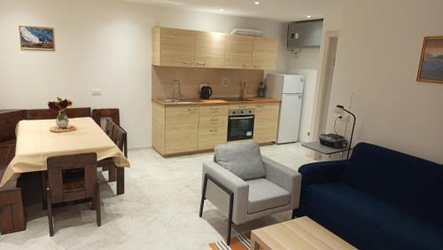 Una cocina y una sala de estar con una mesa y un sofá azul. en Bait de la nef, en Isolaccia