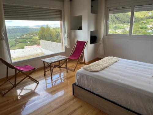 ein Schlafzimmer mit zwei Stühlen, einem Bett und einem Fenster in der Unterkunft Dar Romane in Tangier