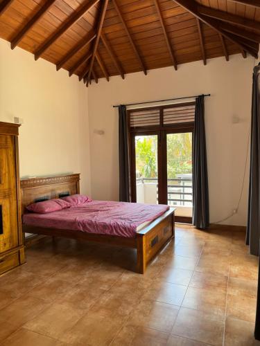 a bedroom with a bed and a large window at PereraTree in Ja-Ela