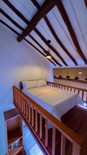 a wooden bed in a room with a ceiling at Hotel Don Eduardo Quintero M in Pinchote