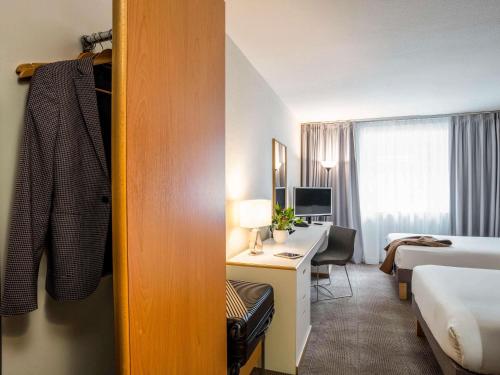 una habitación de hotel con una cama y un escritorio en Novotel Glasgow Centre, en Glasgow