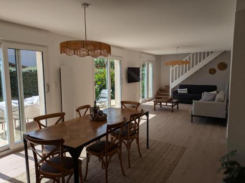 a dining room and living room with a table and chairs at La p'tite marquise in Roscoff