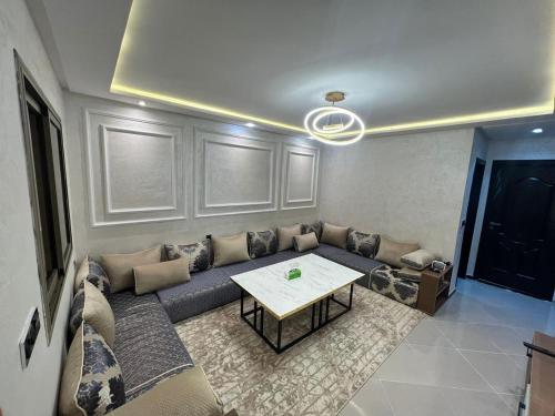 a living room with a couch and a table at Appart de Luxe à LAVERDA - à 400m de la plage in Dakhla