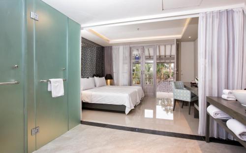 a hotel room with a bed and a bathroom at Segara Village Hotel in Sanur