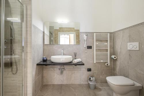 a bathroom with a sink and a toilet and a shower at Dione Ortigia in Siracusa