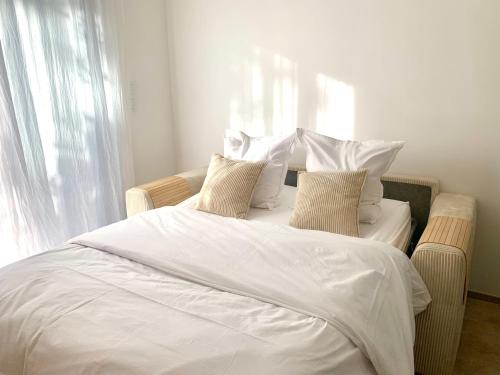 une chambre avec un lit aux draps et oreillers blancs dans l'établissement L'échappée, à Viols-le-Fort
