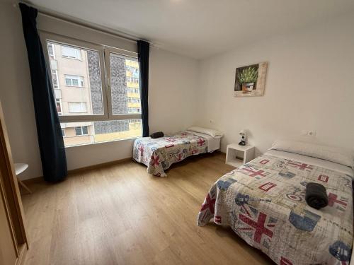 a bedroom with two beds and a large window at SX50 Vut in Lugo