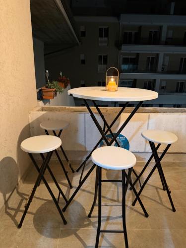 une table avec trois tabourets et une bougie dessus dans l'établissement stelle, à Villa Rosa