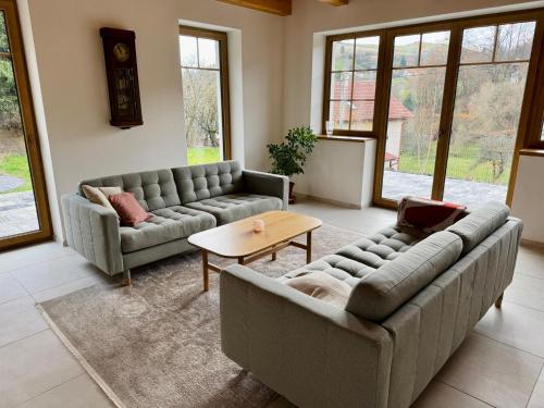 a living room with two couches and a table at Chata pod Jabloňou in Banská Štiavnica