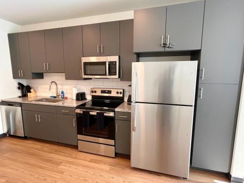 een keuken met roestvrijstalen apparatuur en een witte koelkast bij Purple Palace - Downtown STL Studio in Saint Louis