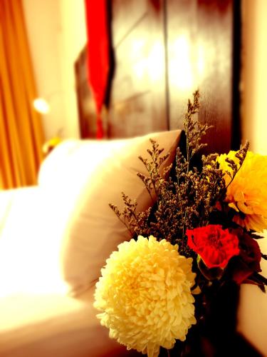 a bouquet of flowers sitting on top of a bed at Boomerang Inn in Patong Beach