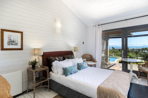 a bedroom with a bed and a balcony with a view at Watermill Ocean View Luxury Family Retreat in Gordonʼs Bay