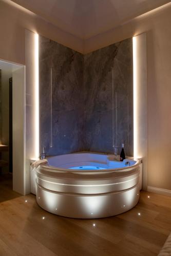 a bath tub in a room with a stone wall at Isidoro Luxury Suites in Palermo