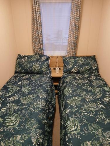 deux lits dans une petite pièce avec une fenêtre dans l'établissement Warm and Cosy, Torbay Waterside Holiday Home, à Paignton