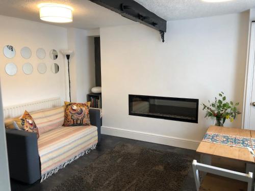 a living room with a couch and a fireplace at The Pathfinder's Retreat - 1 bedroom house for 2-3 guests