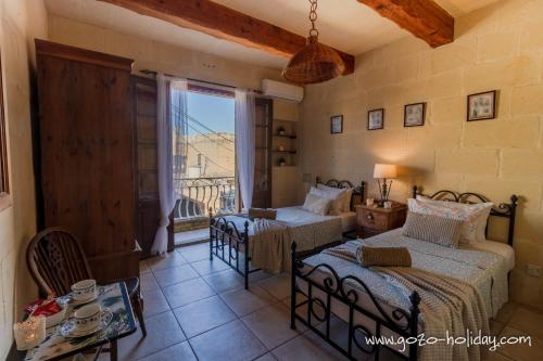 een slaapkamer met twee bedden en een raam bij Tal Lilly Xaghra in Xagħra