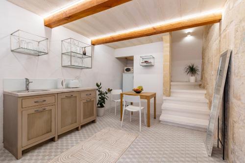 a kitchen with a sink and a table and a staircase at The Glen Residences in Senglea