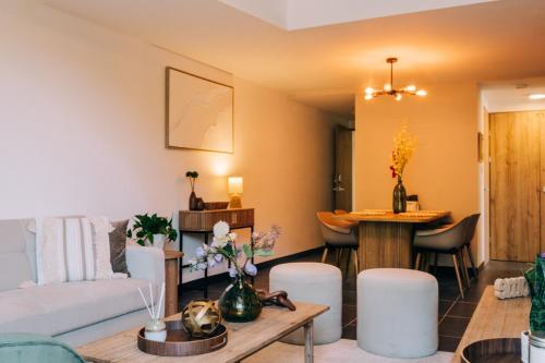 a living room with a couch and a table at NEW Cozy&Modern Apt 30min from SurfCity in Hacienda Plan de La Laguna