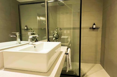 ein weißes Badezimmer mit Waschbecken und Dusche in der Unterkunft RentUp - Moderno y Luminoso Studio Premium con Amenities en el corazon de Buenavista in Estación San Isidro