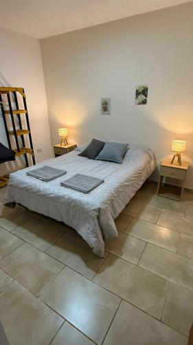 a bedroom with a large bed with two lamps at La posada de Majo 2 in Pergamino