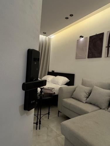 a living room with a television and a couch at Luxury studio with smart self check-in أستديو راقي بدخْول ذاتي حي الصحافة in Riyadh