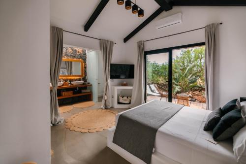 ラハレスにあるVilla Shepherd Lajares - LUXURY VILLA FUERTEVENTURAの大きなベッドとバルコニーのある寝室