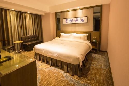 a hotel room with a large bed and a mirror at INSAIL Hotel (Shenzhen Dongmen Branch) in Shenzhen