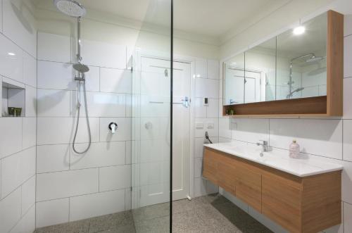 ein Badezimmer mit Dusche und Waschbecken in der Unterkunft Grasmere Farm in Gruyere