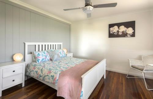 ein Schlafzimmer mit einem Bett und einem Deckenventilator in der Unterkunft Grasmere Farm in Gruyere