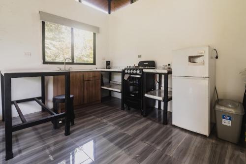 Una cocina con un refrigerador blanco y un fregadero. en Newly built Surf Hideaway in Avellanas Beach, en Playa Avellana