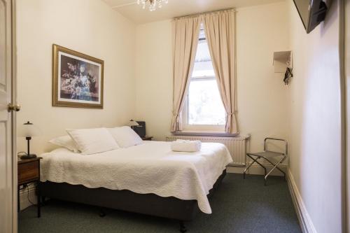 a bedroom with a bed and a window at Lancefield Guest House in Lance Field