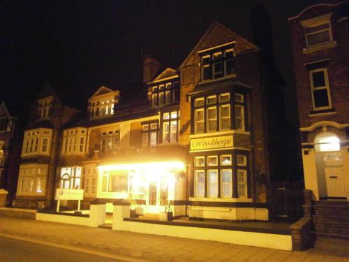 a lit up building on a city street at night at Woodthorpe Hotel in Skegness