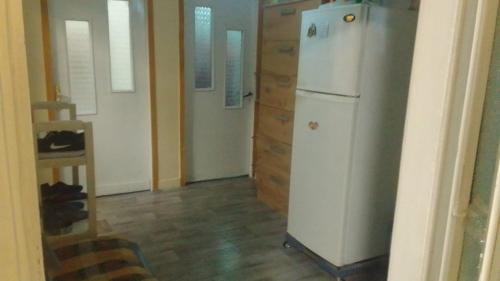 a kitchen with a white refrigerator in a room at ROYAL Hostel in Tirana
