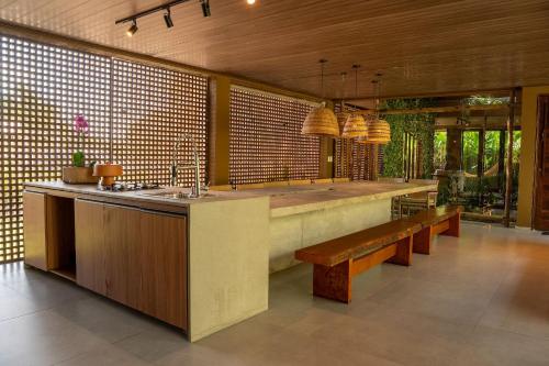 a kitchen with benches and a counter with a sink at Casa com Ofurô, Piscina Aquecida e Cozinheira in Barra do Camaragibe
