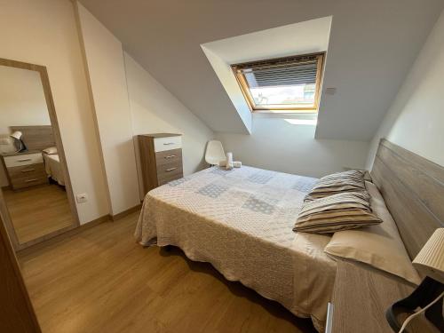 a bedroom with a bed and a dresser and a window at SF40 Vut in Lugo