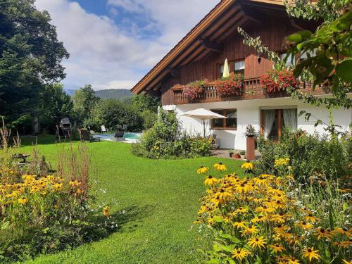 a garden in front of a house with flowers at Ferienwohnung In Bayerisch Eisenstein Mit Garten in Bayerisch Eisenstein