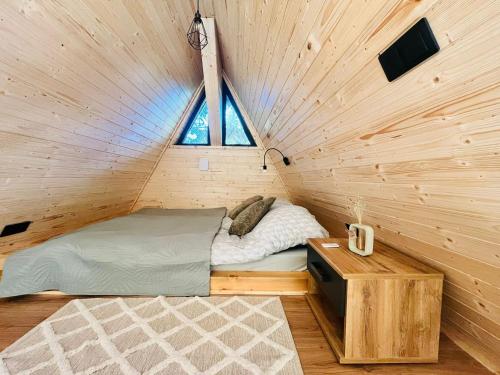 a bed in a wooden room with a window at Lunascape in Sîntimbru-Băi