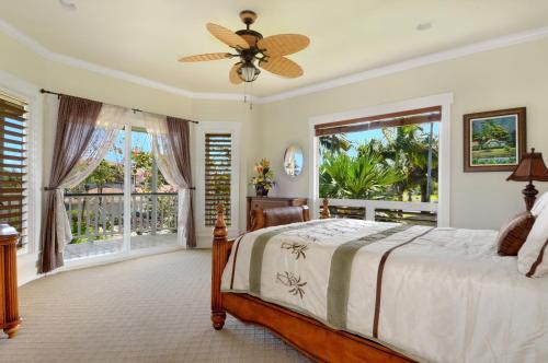 a bedroom with a bed and a large window at Princeville/Hanalei Lux 4BR 3.5Ba w/AC+CAR in Princeville
