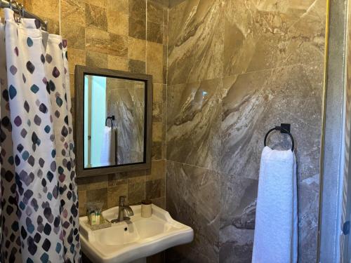 ein Badezimmer mit Waschbecken und Spiegel in der Unterkunft The Ridge - Stone Cottage in Buff Bay